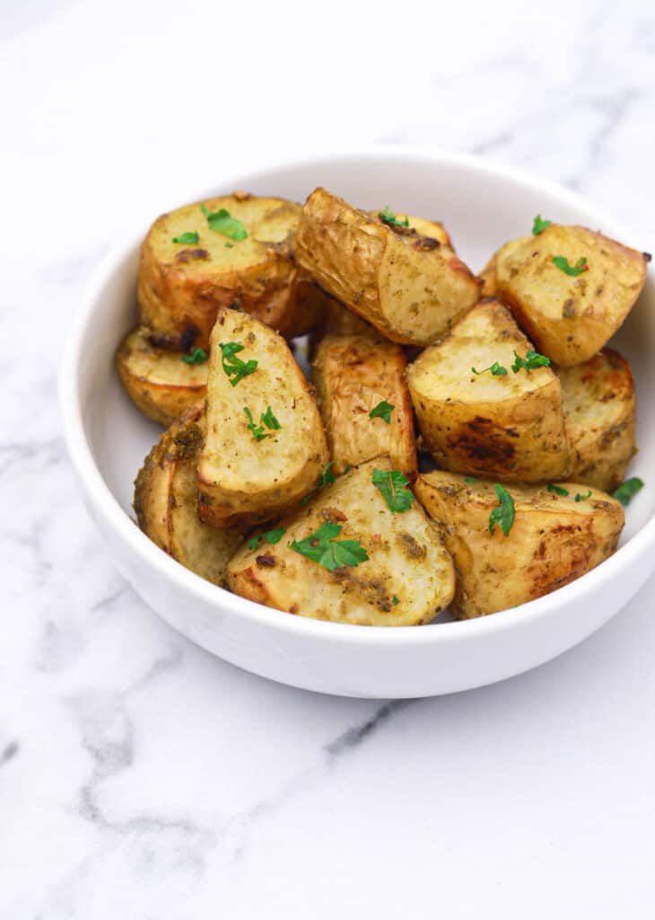 pesto potatoes served in a white bowl.