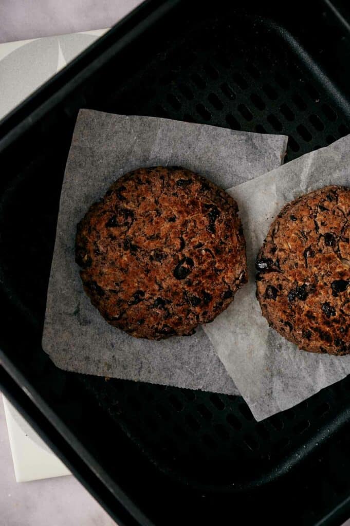 Air fried black bean burgers in an air fryer basket.