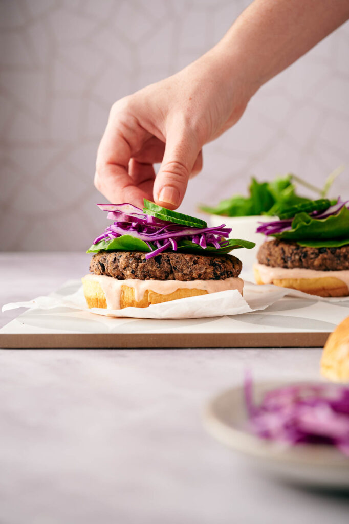 Garnishing an air fried black bean burger.