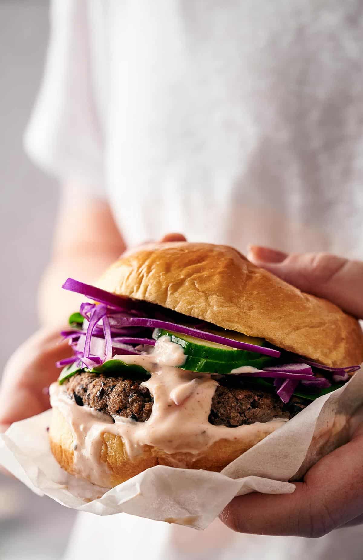 Someone holding an air fryer black bean burger.